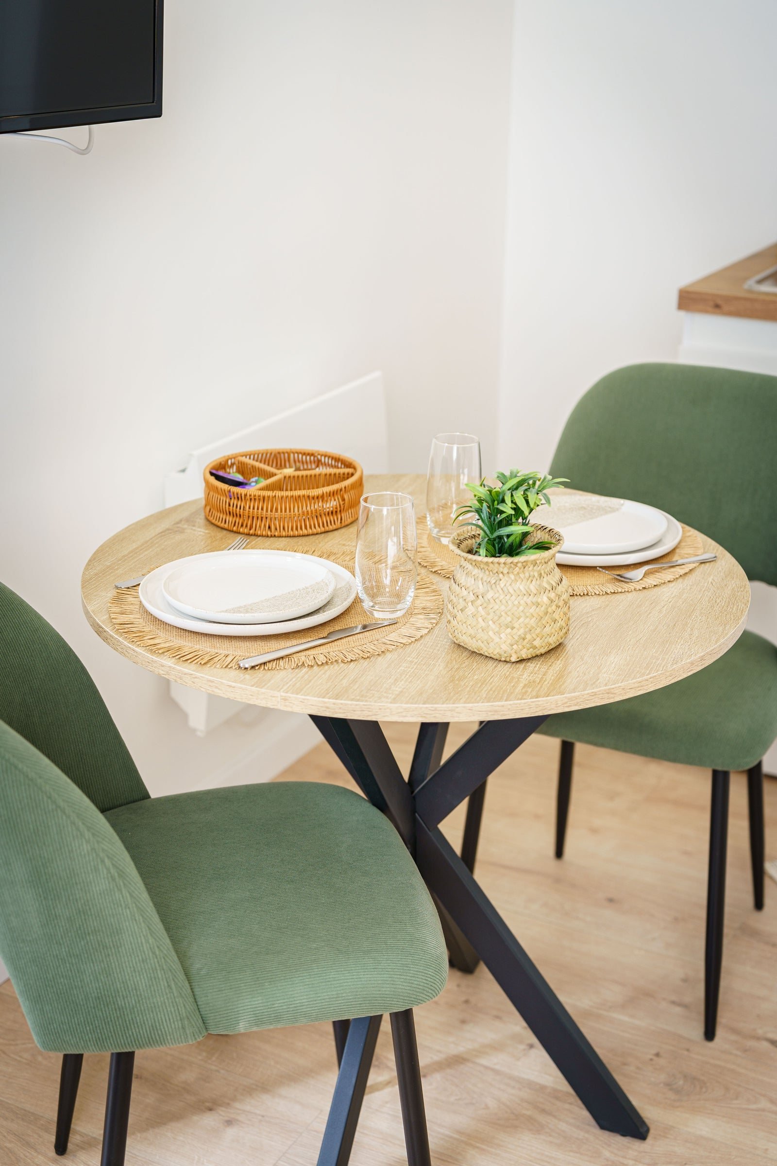 Table dressée aux chaises vertes dans un appartement AppartCosy